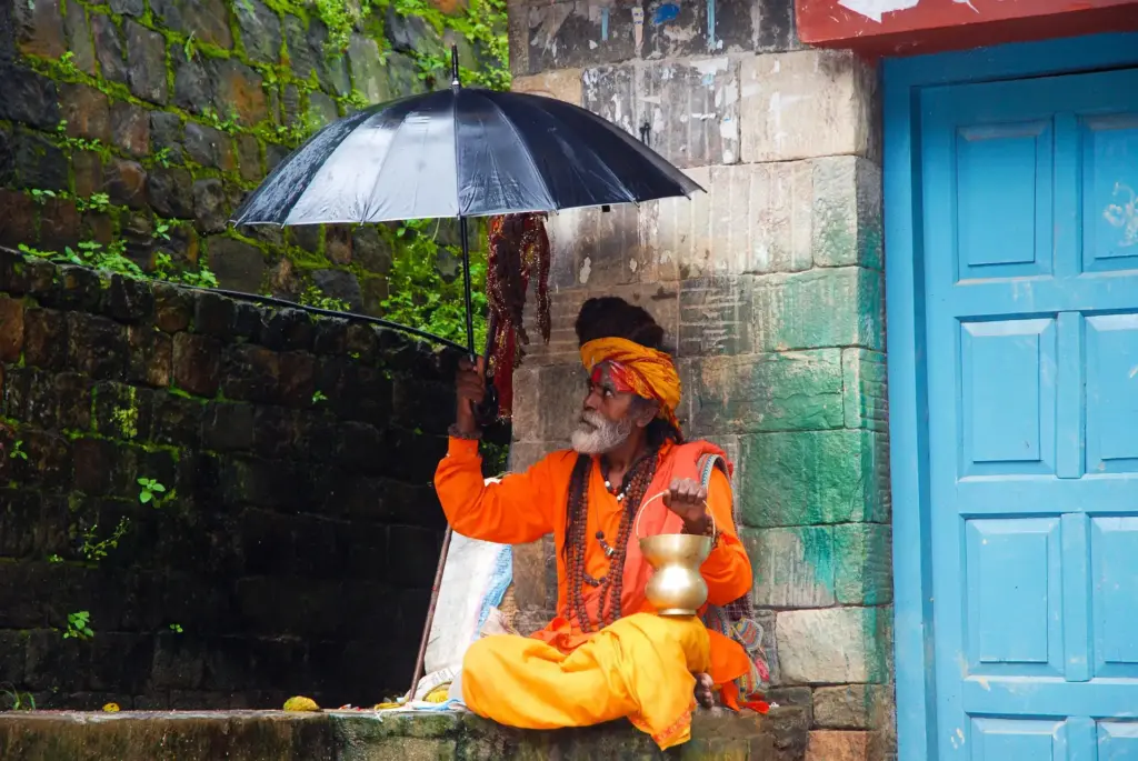 Indischer Guru mit Regenschirm